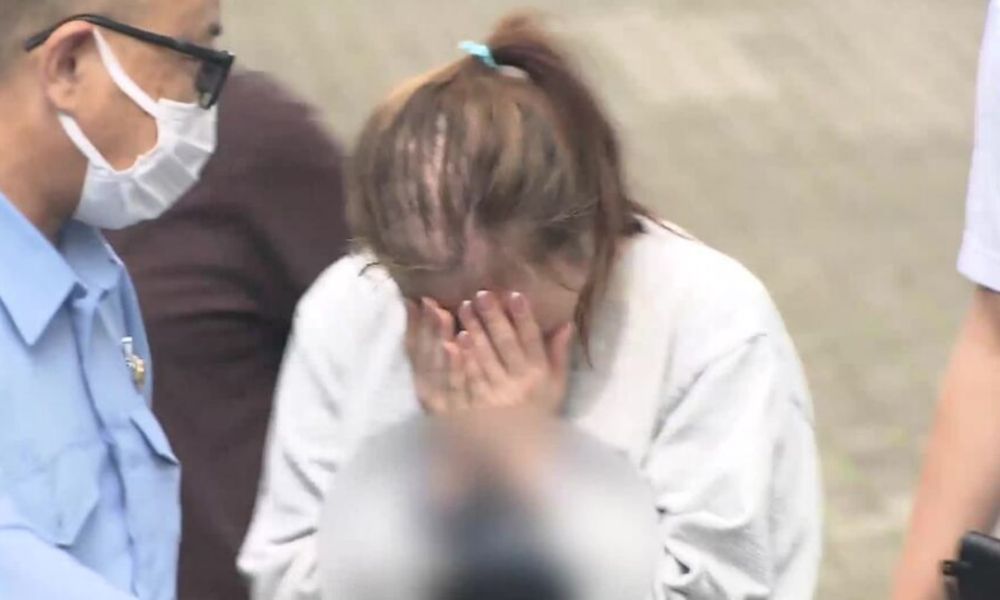 慶応大学4年・新沢かれん容疑者が逮捕時に両手で顔を覆う様子(2026年8月17日)